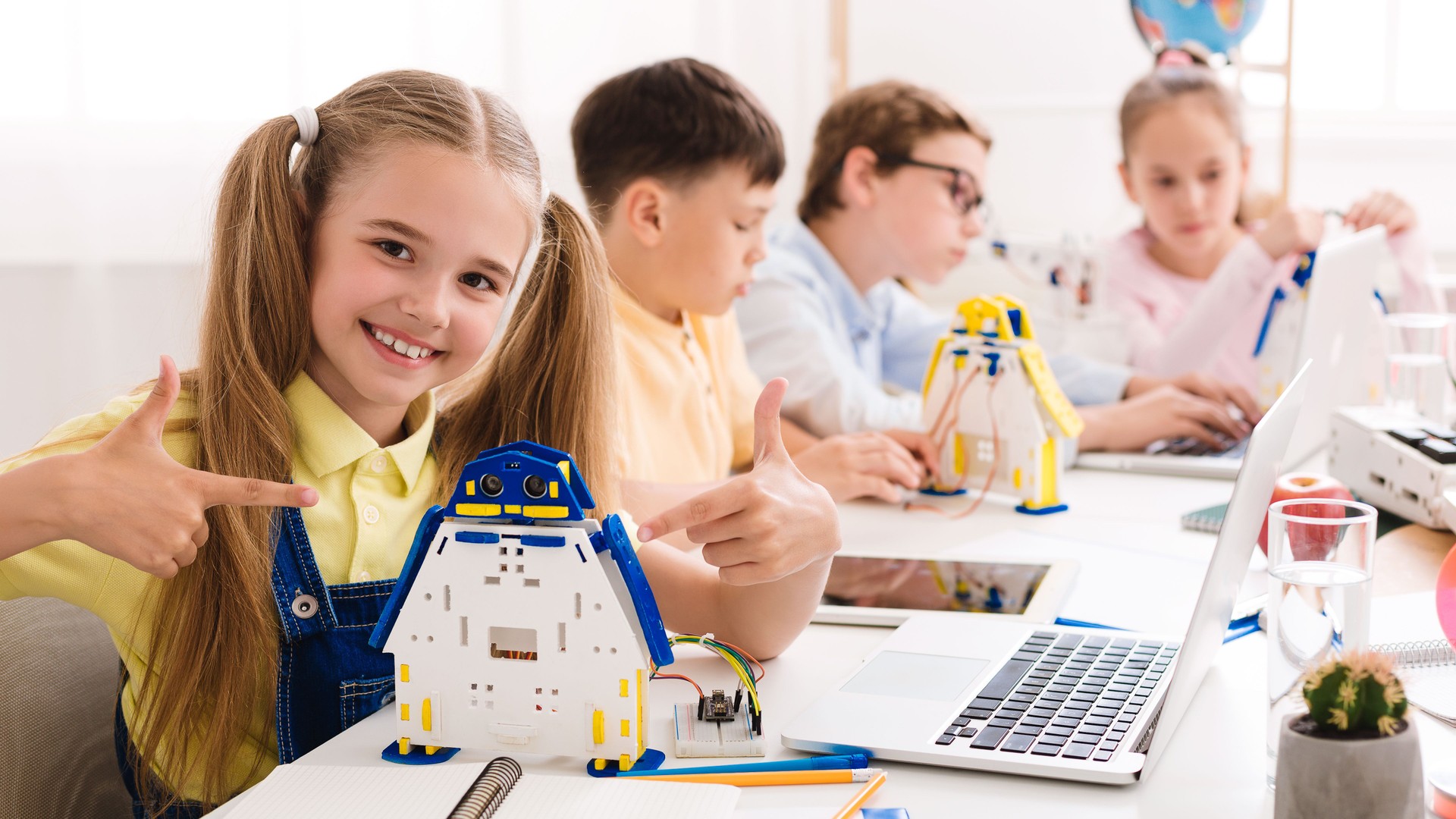 Young Students Engage in a Robotics Workshop While Showcasing Their Creations at a Bright Classroom